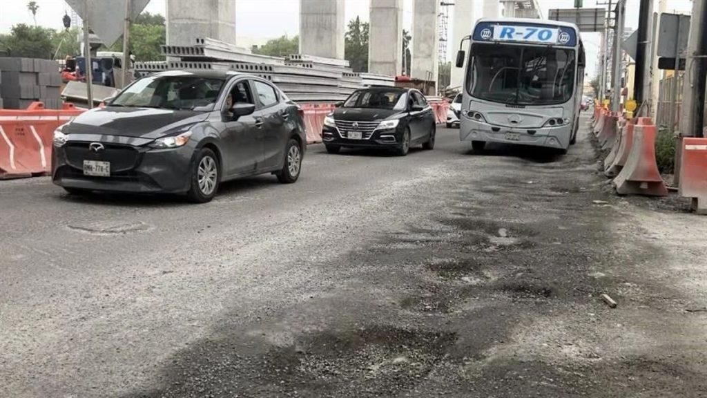 Road Under Construction with Orange Barriers and Uneven Pavement; Three Cars and a White Bus in Traffic Near Construction Site. › Regiadísticas