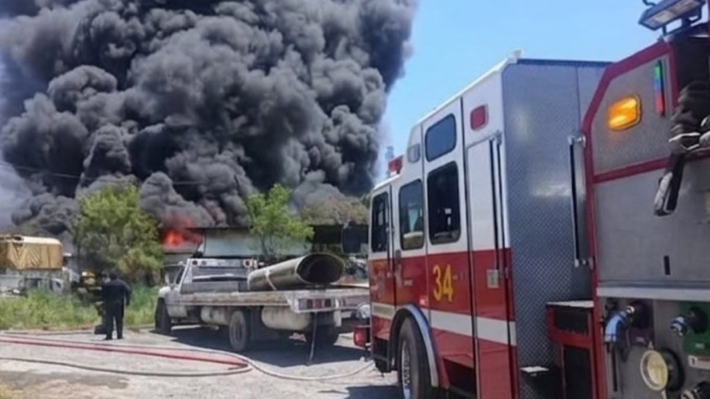 Falta-de-alertas-en-nuevo-leon › Regiadísticas Emergency Scene with a Large Black Smoke Plume, a Burning Building, and a Red Fire Engine in the Foreground to the Right. › Regiadísticas