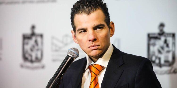 Man in a Dark Suit with an Orange Striped Tie Speaks into a Microphone at a Conference or Event. › Regiadísticas